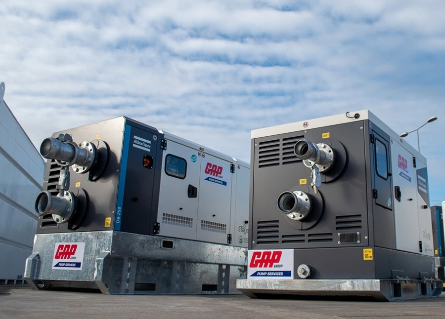 Two GAP Group Pump Services pump units parked outside under a blue sky