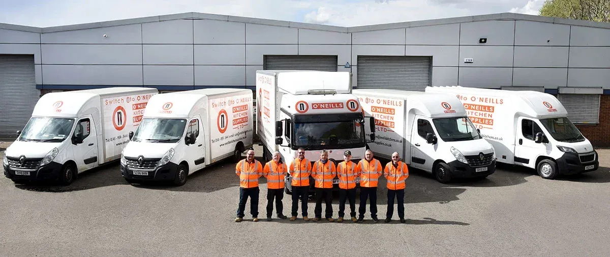 The O'Neills Kitchen Supplies team in hi-vis in front of their branded delivery vans