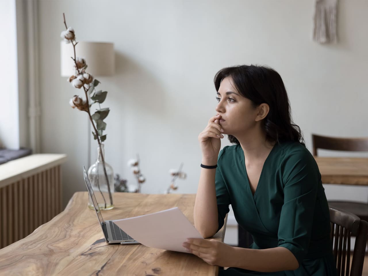 Woman sitting at a table reading a document